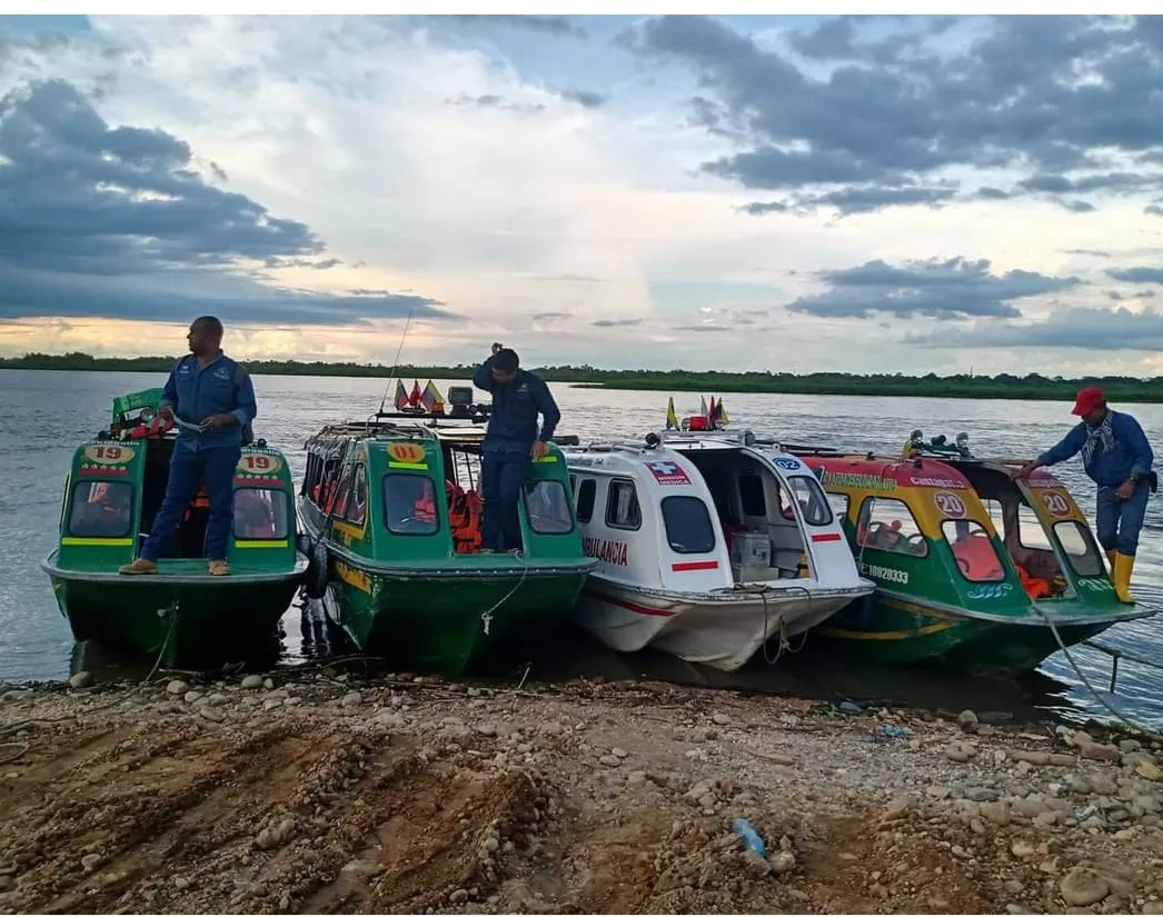 Tripulación de COOTRANSFLUCAN junto a su flota, incluida la ambulancia fluvial, al atardecer