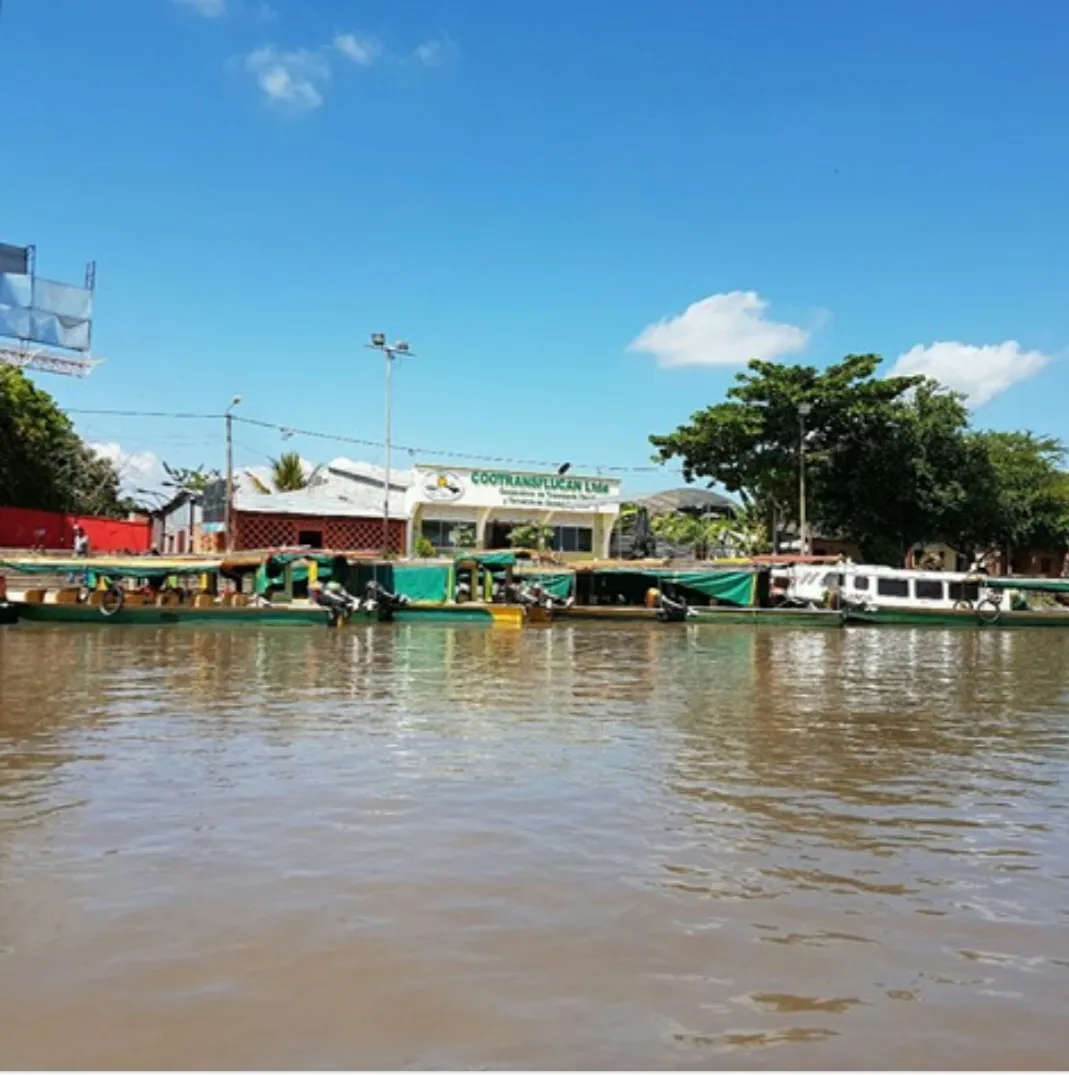 Muelle y sede de COOTRANSFLUCAN vistos desde el río, con la flota en fibra de vidrio atracada